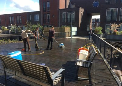 Schoonmaken van vlonder bij appartementencomplex